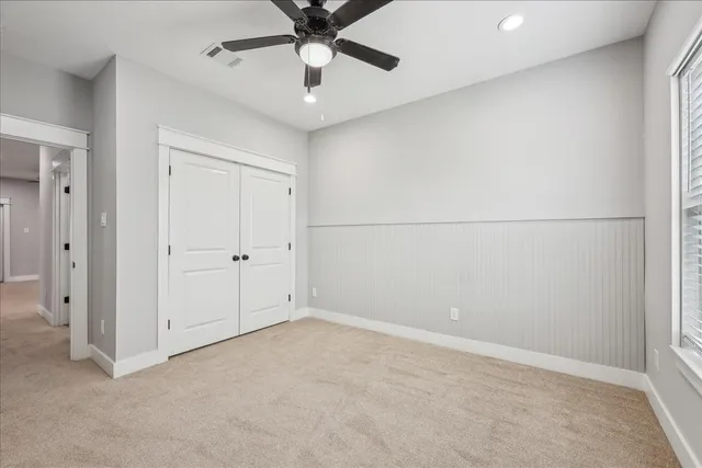 an empty room with a ceiling fan and a window