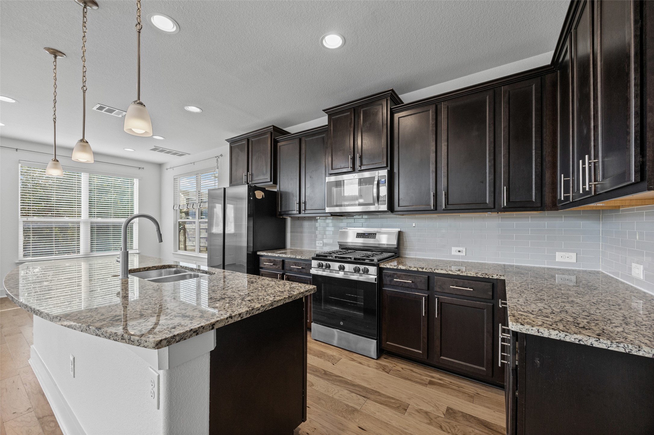 2303 Capulet Street Austin, TX 78741 - Photo 6 of 24 The kitchen also offers abundant cabinetry and generous granite counter space for easy meal preparation and storage. A spacious island provides additional workspace, seating, and a natural gathering place for guests.