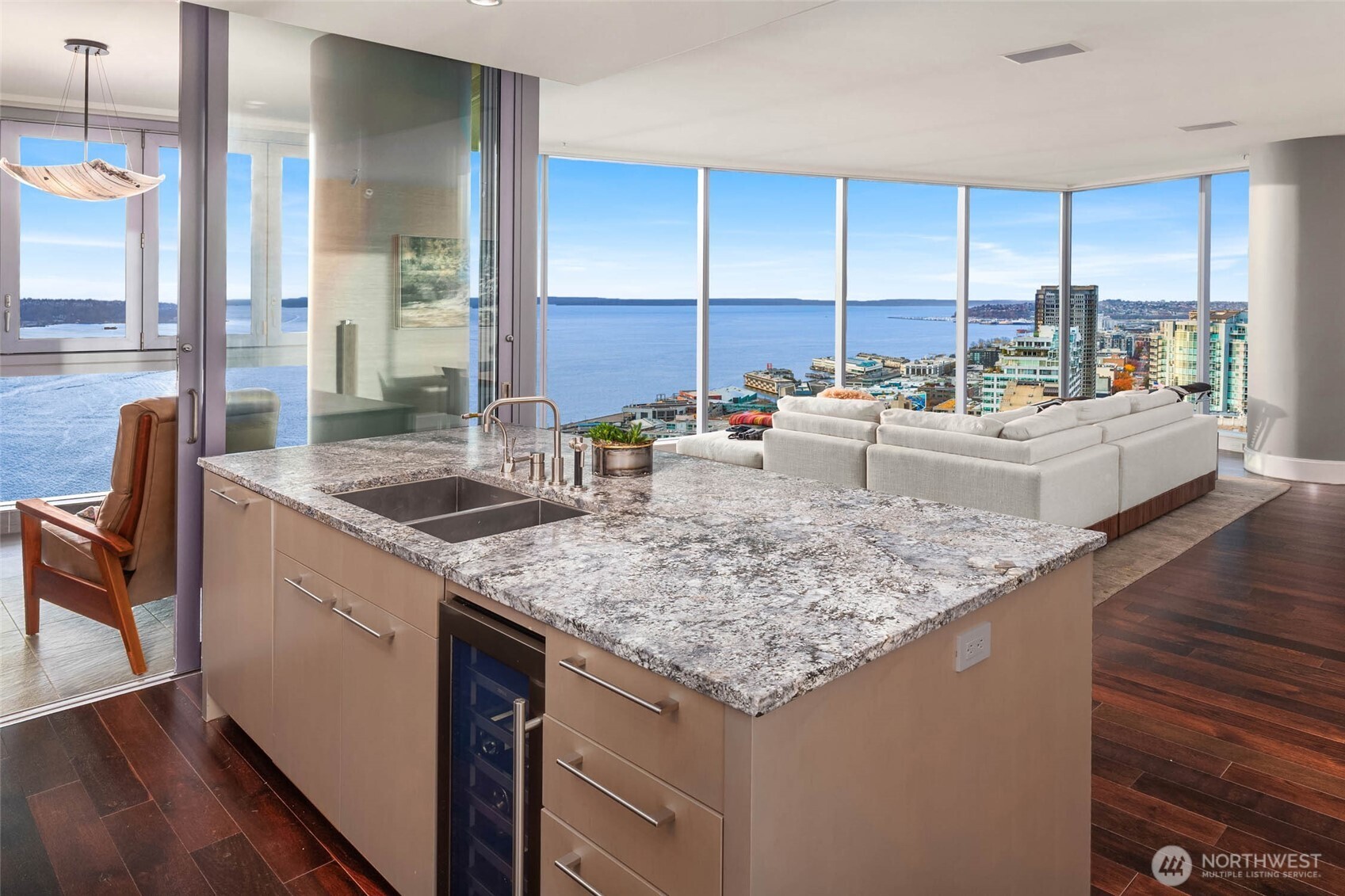 1521 2nd Avenue, Unit 2800 Seattle, WA 98101 - Photo 14 of 35 a kitchen with kitchen island granite countertop a sink a counter top space and living room view
