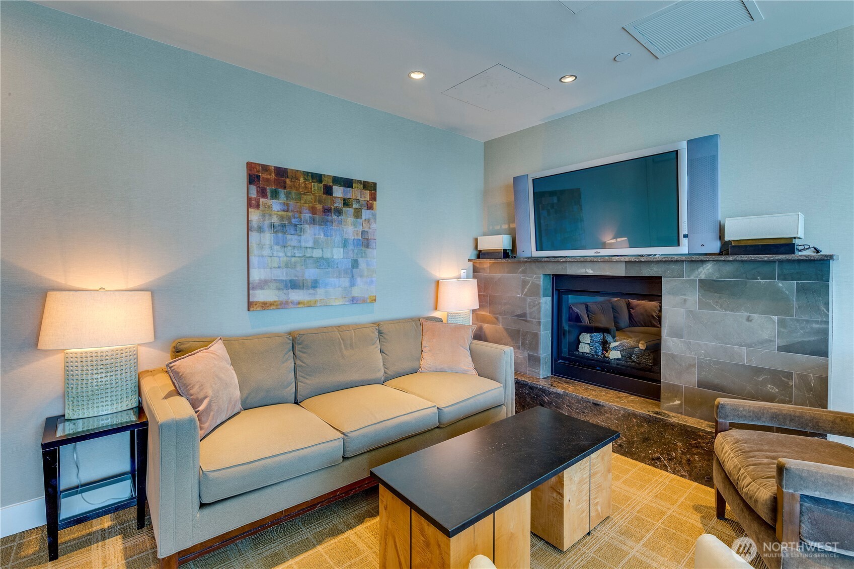 1521 2nd Avenue, Unit 2800 Seattle, WA 98101 - Photo 31 of 35 a living room with furniture a flat screen tv and a fireplace