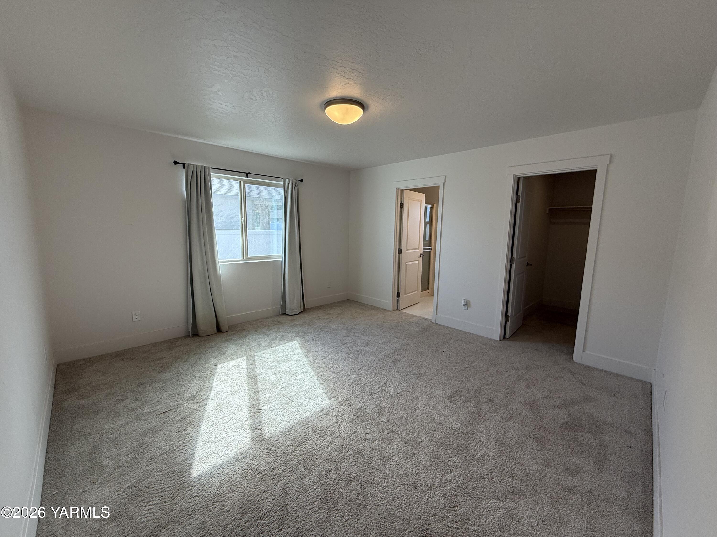707 Grapevine Street Grandview, WA 98930 - Photo 5 of 14 an empty room with windows and entrance