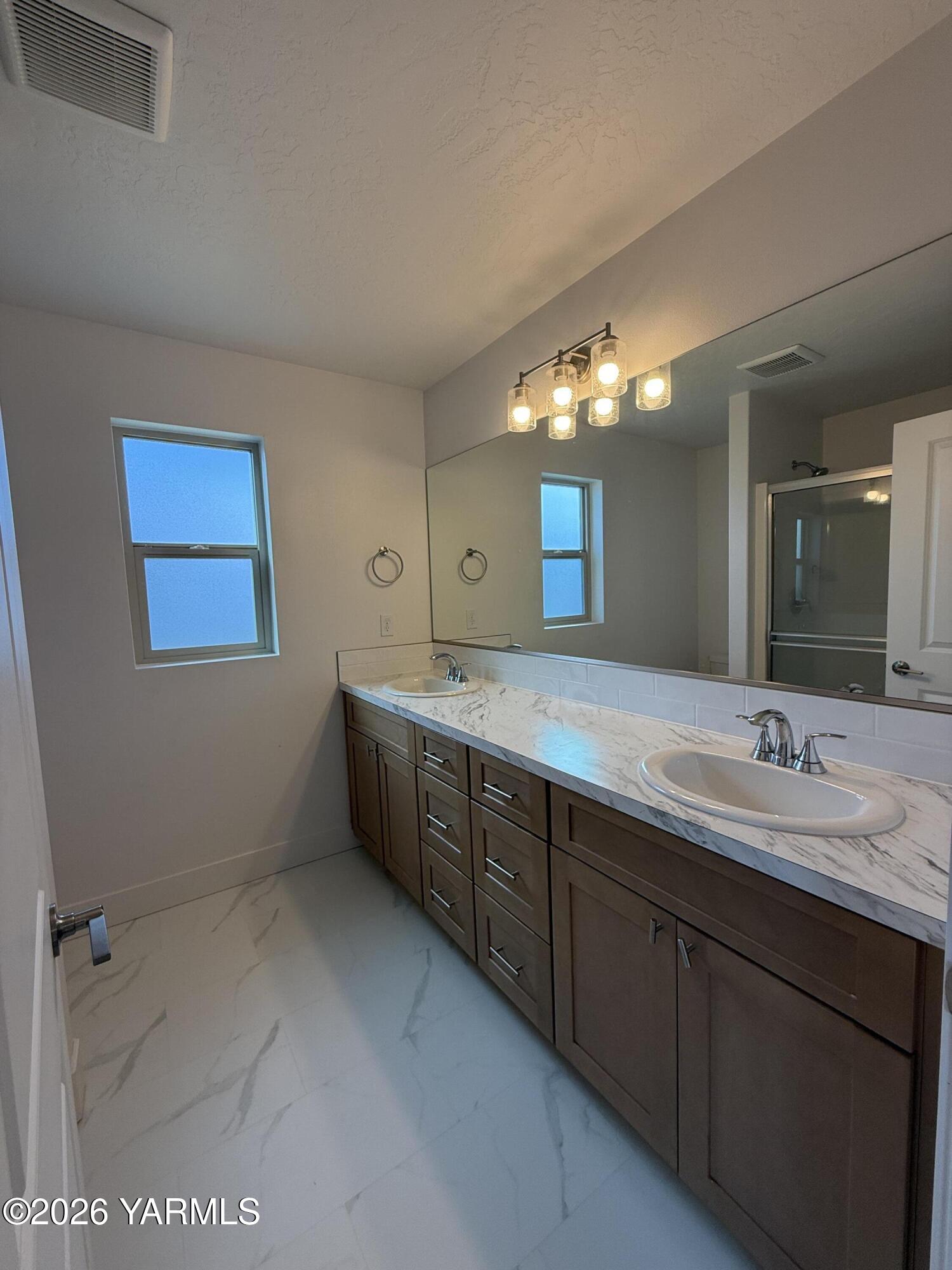707 Grapevine Street Grandview, WA 98930 - Photo 6 of 14 a spacious bathroom with a double vanity sink and a mirror