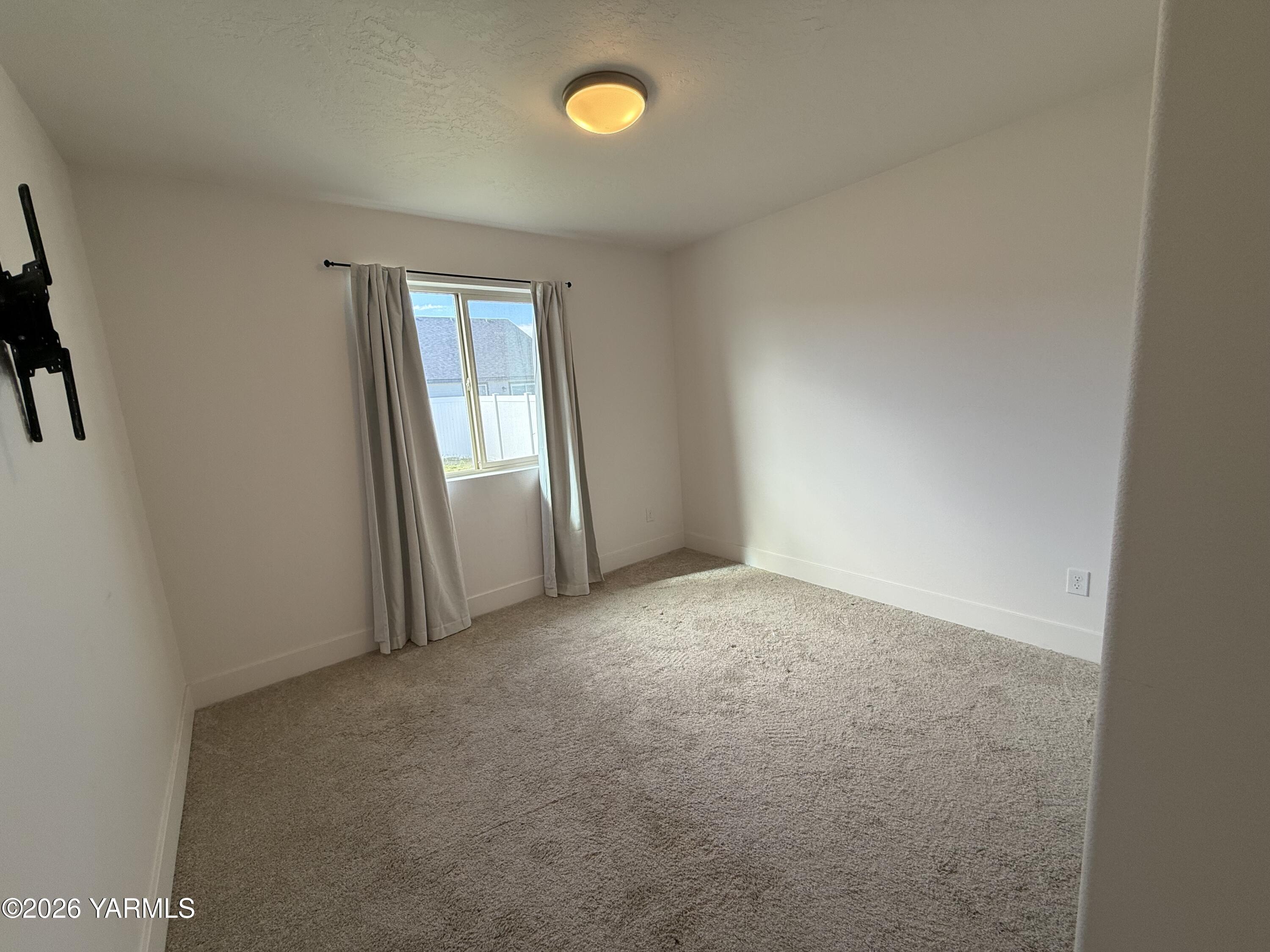 707 Grapevine Street Grandview, WA 98930 - Photo 9 of 14 an empty room with windows and closet