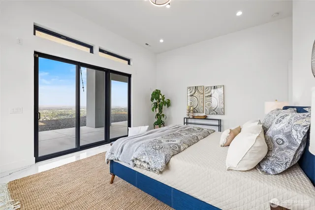 a bedroom with a large bed and a potted plant