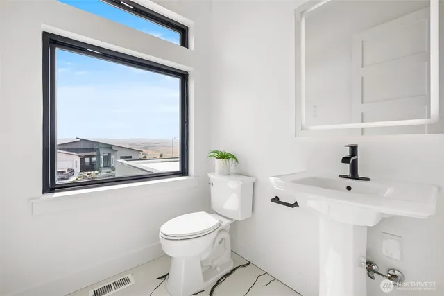 a bathroom with a toilet a sink and a window