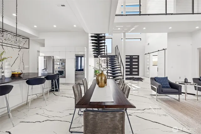 a kitchen with stainless steel appliances kitchen island granite countertop a stove and a living room view