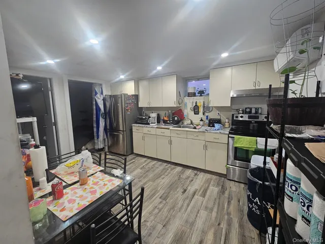 a kitchen with stainless steel appliances kitchen island granite countertop a sink cabinets and wooden floor