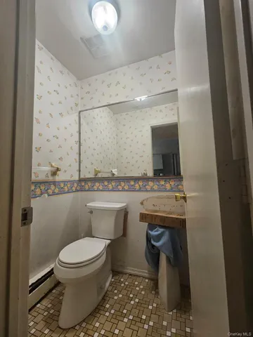 a bathroom with a toilet sink and mirror