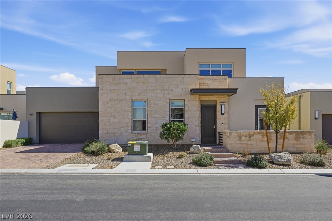 4246 Swift Street Las Vegas, NV 89135 - Photo 1 of 71 Contemporary home with stone siding, a garage, driveway, and stucco siding