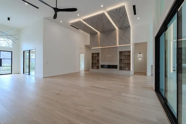 an empty room with wooden floor and windows