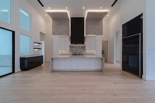 a living room with stainless steel appliances kitchen island granite countertop a stove and a refrigerator