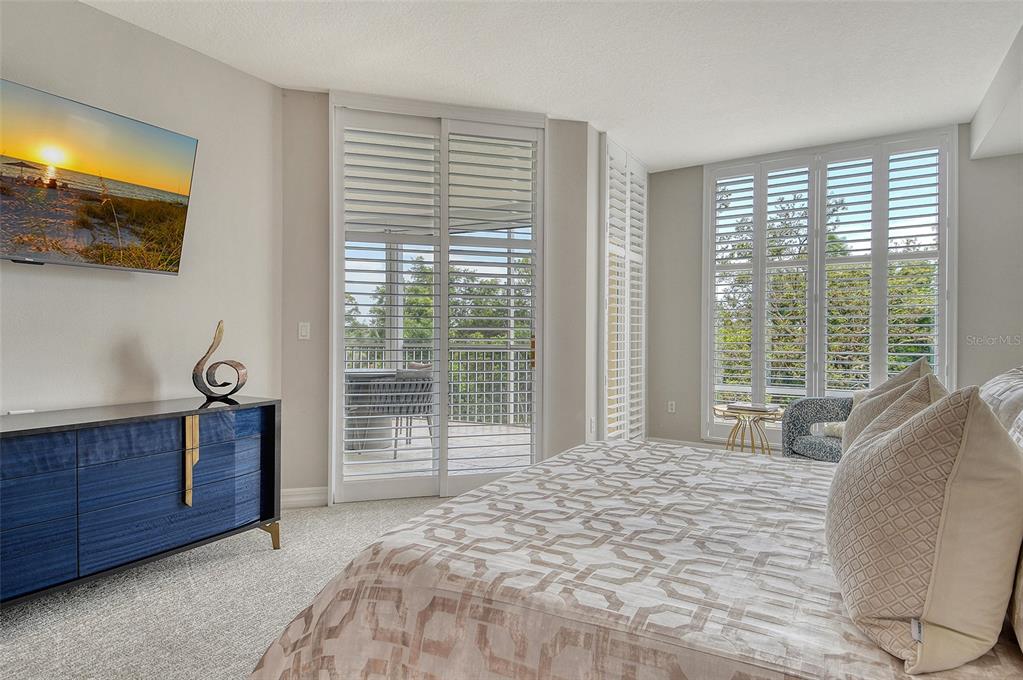 401 North Point Road, Unit 304 Osprey, FL 34229 - Photo 34 of 95 a bed sitting in a spacious bedroom next to a window