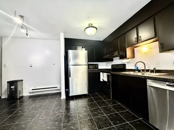 a kitchen with a sink a refrigerator and cabinets