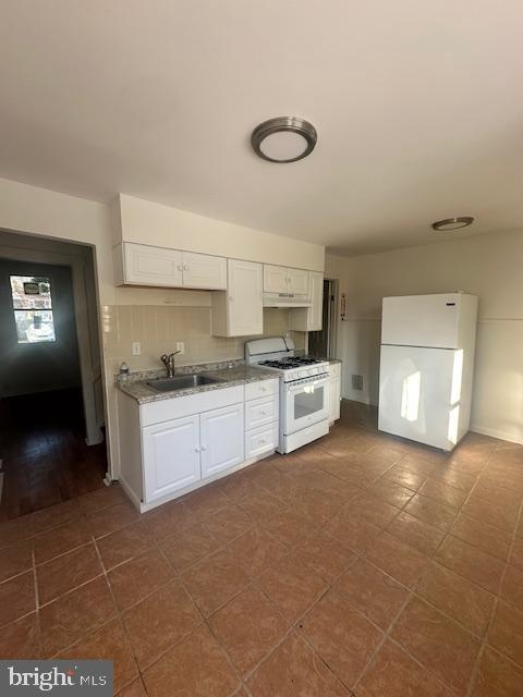1082 Trent Road Camden, NJ 08104 - Photo 4 of 9 a large white kitchen with a sink and dishwasher a stove top oven with white cabinets
