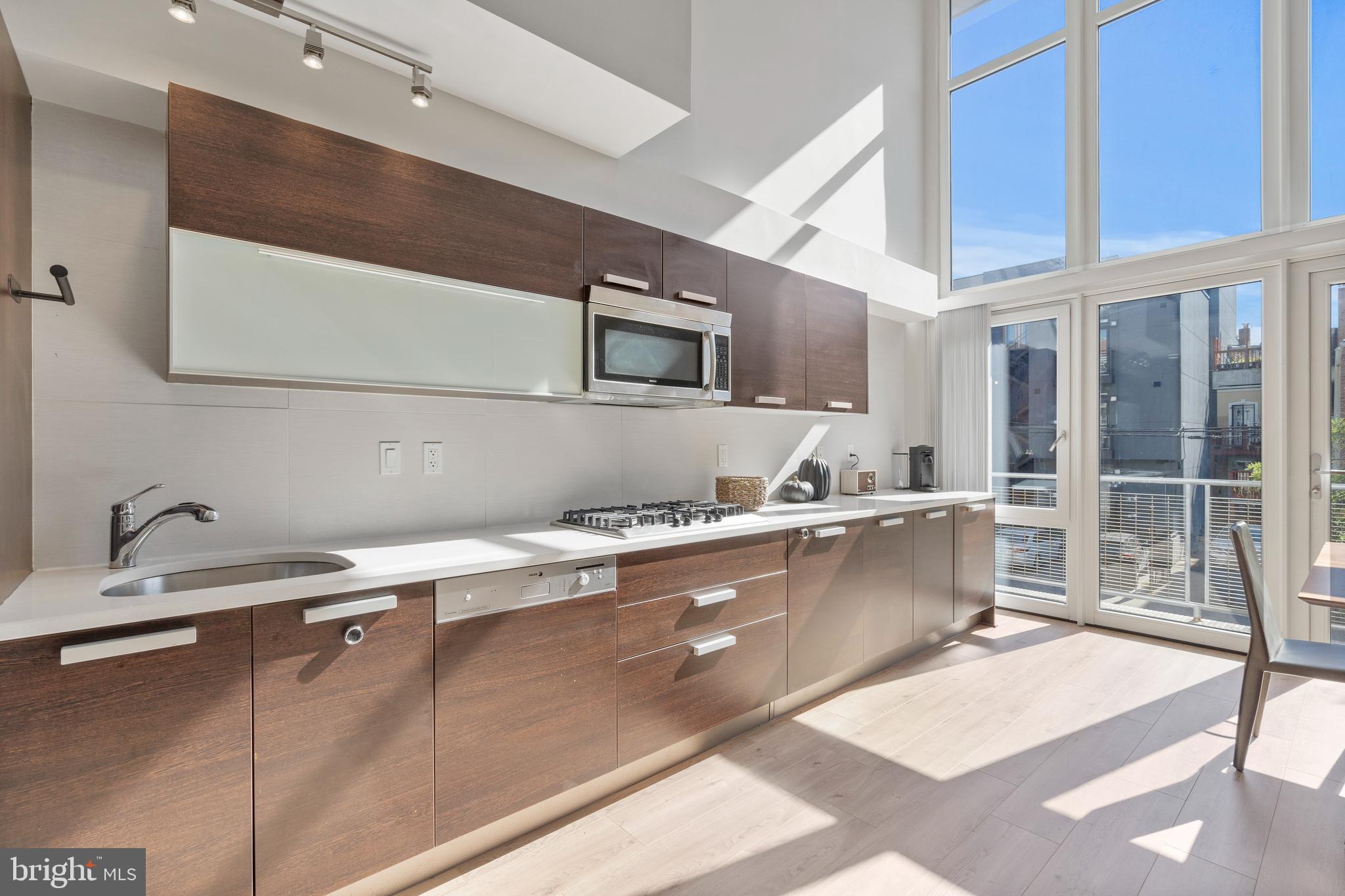 1466 Harvard Street Northwest, Unit A2 Washington, DC 20009 - Photo 11 of 31 a large kitchen with stainless steel appliances a large counter top a stove and a sink
