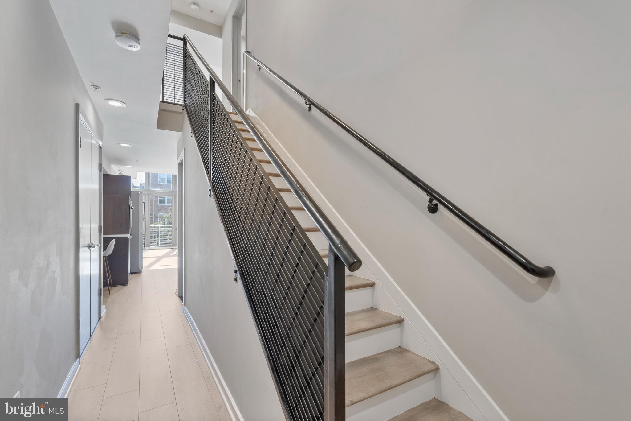 1466 Harvard Street Northwest, Unit A2 Washington, DC 20009 - Photo 10 of 31 a view of staircase with lots of frames on wall and wooden floor