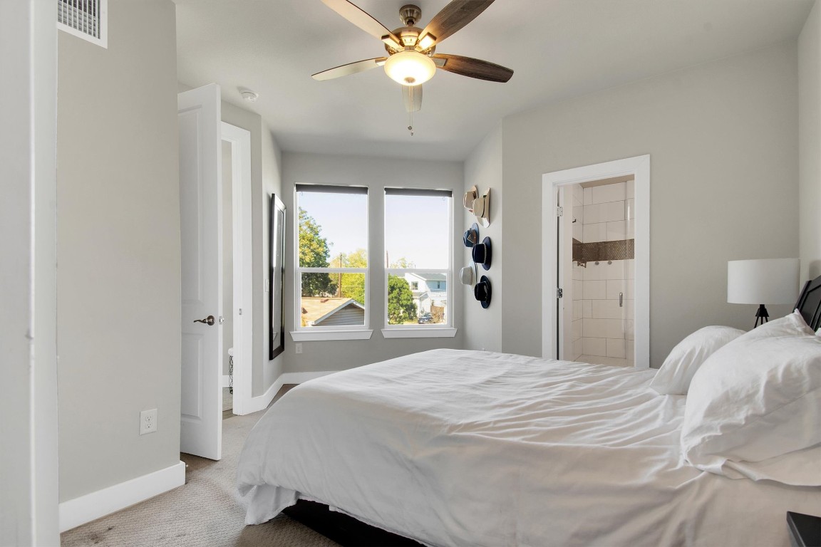 1905 Alegria Road, Unit B Austin, TX 78757 - Photo 13 of 25 Serene Primary Bedroom – Spacious and bright with neutral tones, plush carpet, and a calm, modern feel—your perfect retreat after a long day.