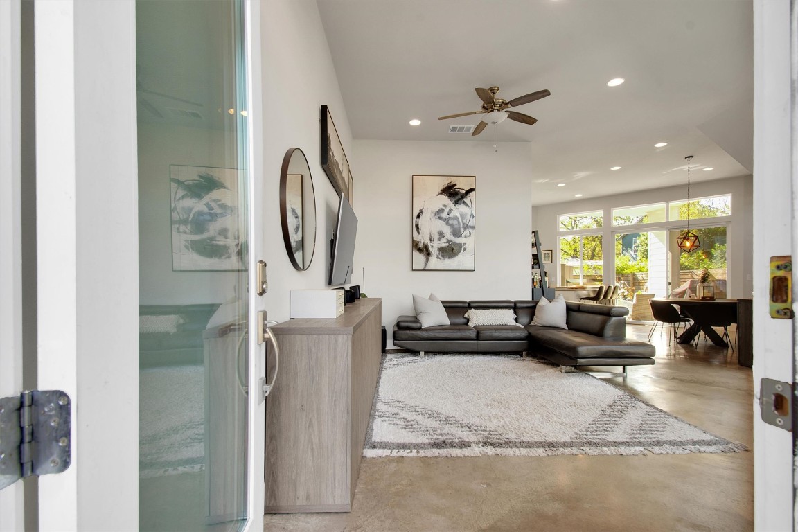 1905 Alegria Road, Unit B Austin, TX 78757 - Photo 6 of 25 A bright, open-concept living and dining area with 14’ ceilings, polished concrete floors, and walls of windows that bring the outdoors in. Perfect for entertaining, relaxing, or enjoying the seamless flow from the kitchen to the private patio.