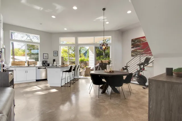 a dining room filled chandelier and wooden floor