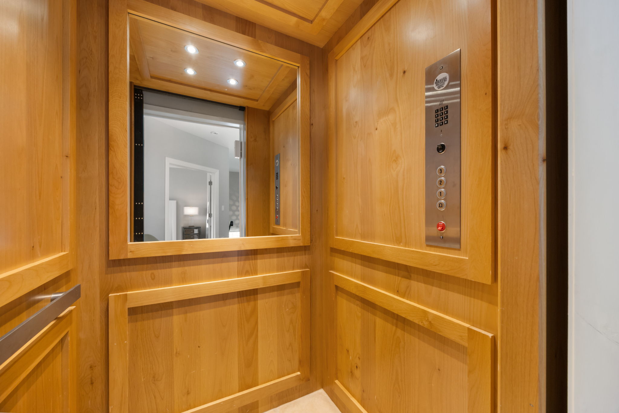 1910 Rue De St Tropez, Unit 6 Austin, TX 78746 - Photo 20 of 37 Step into this elegant residential elevator, featuring warm wood paneling and convenient controls.