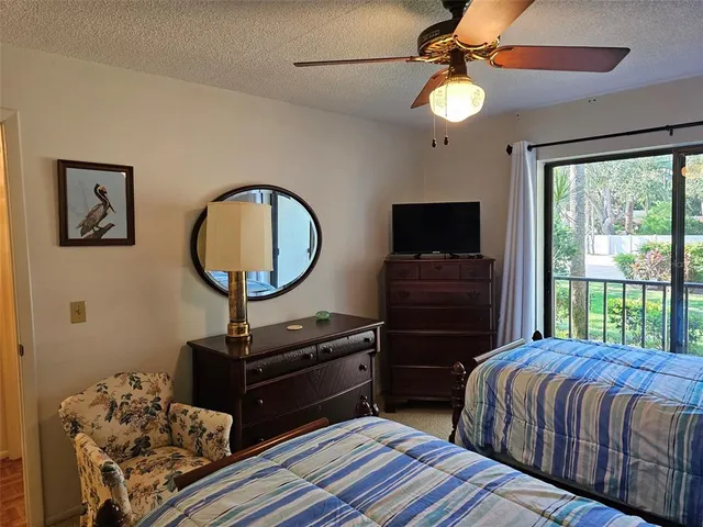 a bedroom with a bed and a flat tv screen on the dresser