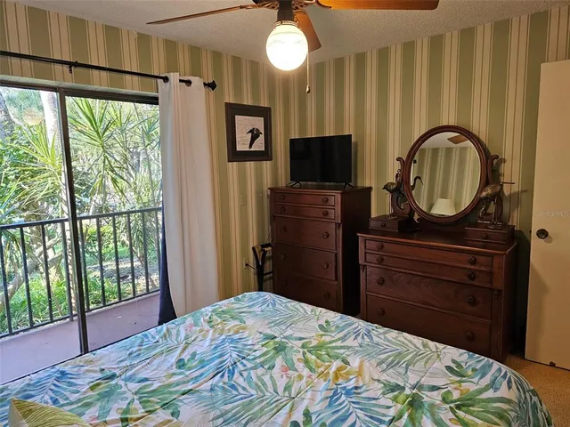 a bedroom with a bed and a flat tv screen on dresser