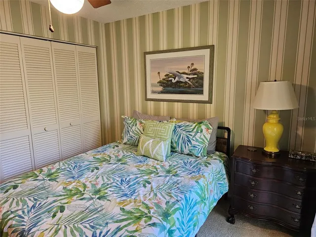 a bedroom with a bed and a lamp on dresser