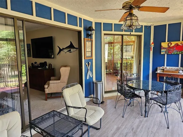 a living room with furniture a flat screen tv and floor to ceiling windows