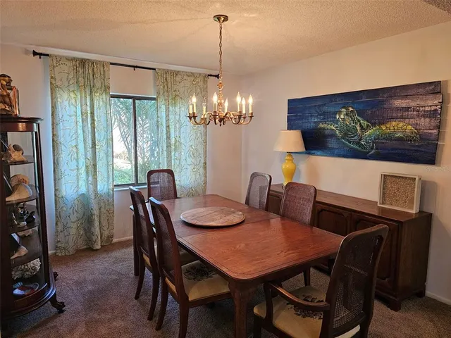a view of a dining room with furniture and chandelier