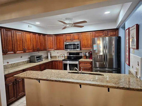 a kitchen with stainless steel appliances granite countertop a refrigerator a stove top oven a sink and dishwasher