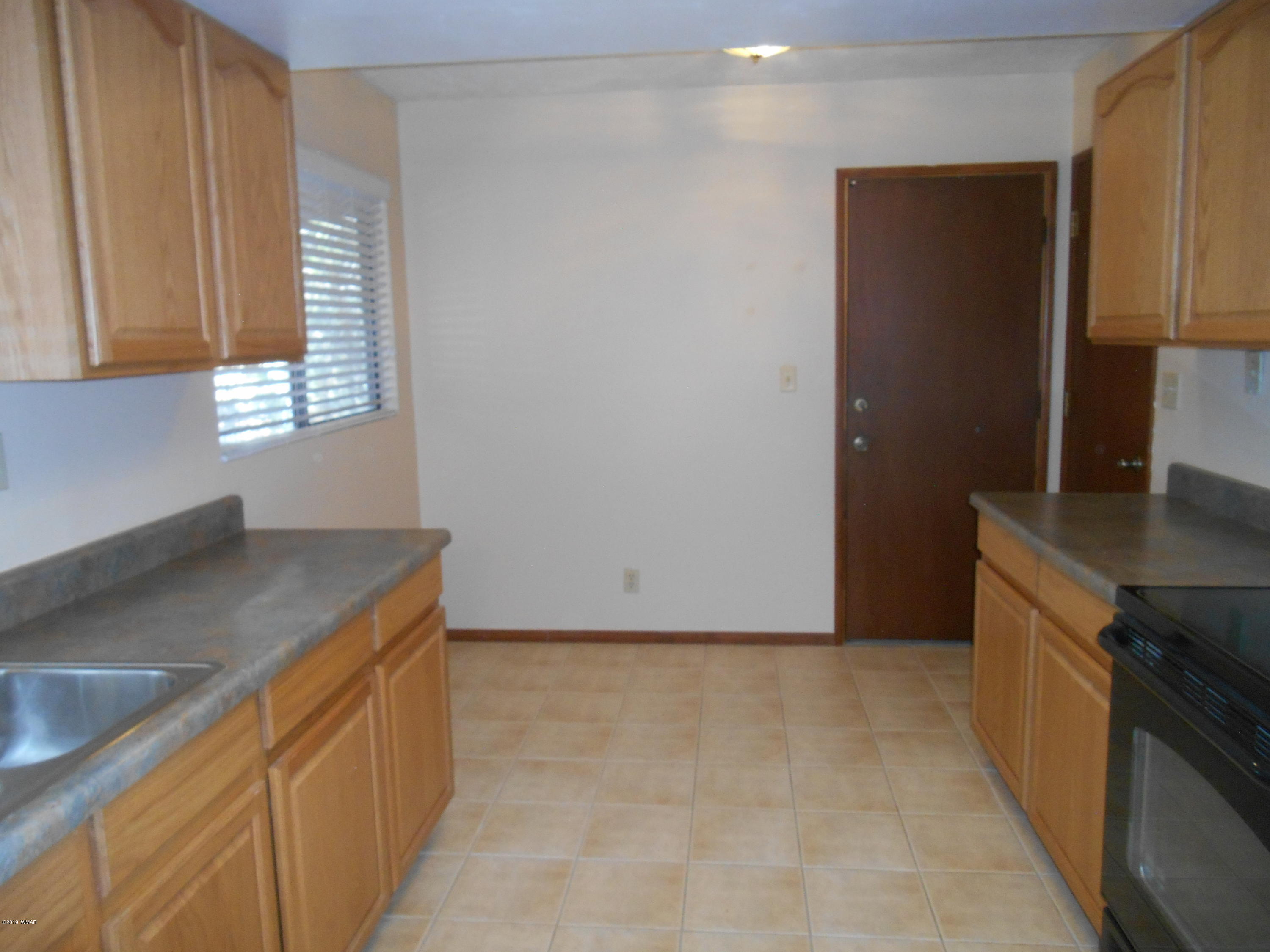 2141 Wildflower Road Overgaard, AZ 85933 - Photo 4 of 21 a kitchen with a sink and a refrigerator