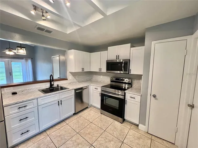 a kitchen with granite countertop a sink stainless steel appliances and cabinets