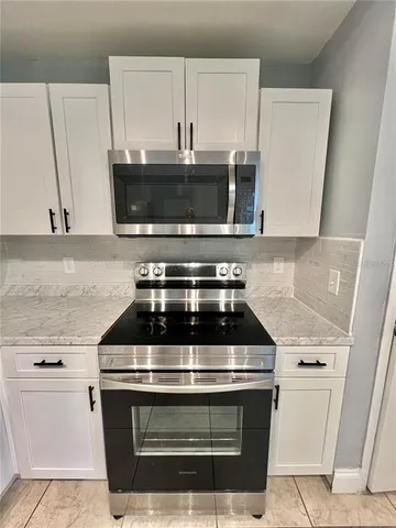 a stove top oven sitting inside of a kitchen