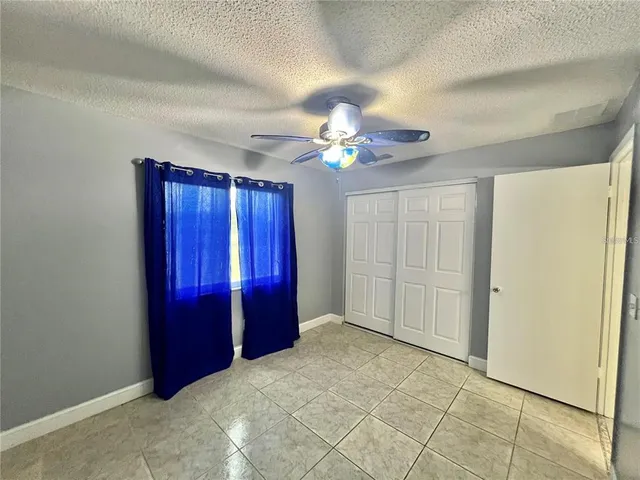 an empty room with closet and chandelier fan