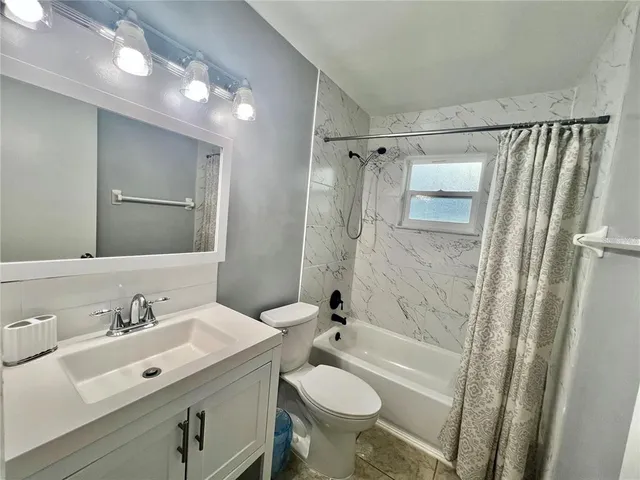 a bathroom with a sink toilet tub and shower