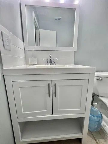 a bathroom with a sink a toilet and a mirror