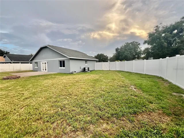 a large pool that has lawn chairs with a yard