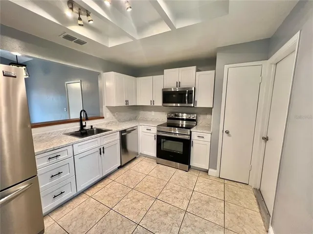 a kitchen with stainless steel appliances a refrigerator sink and microwave