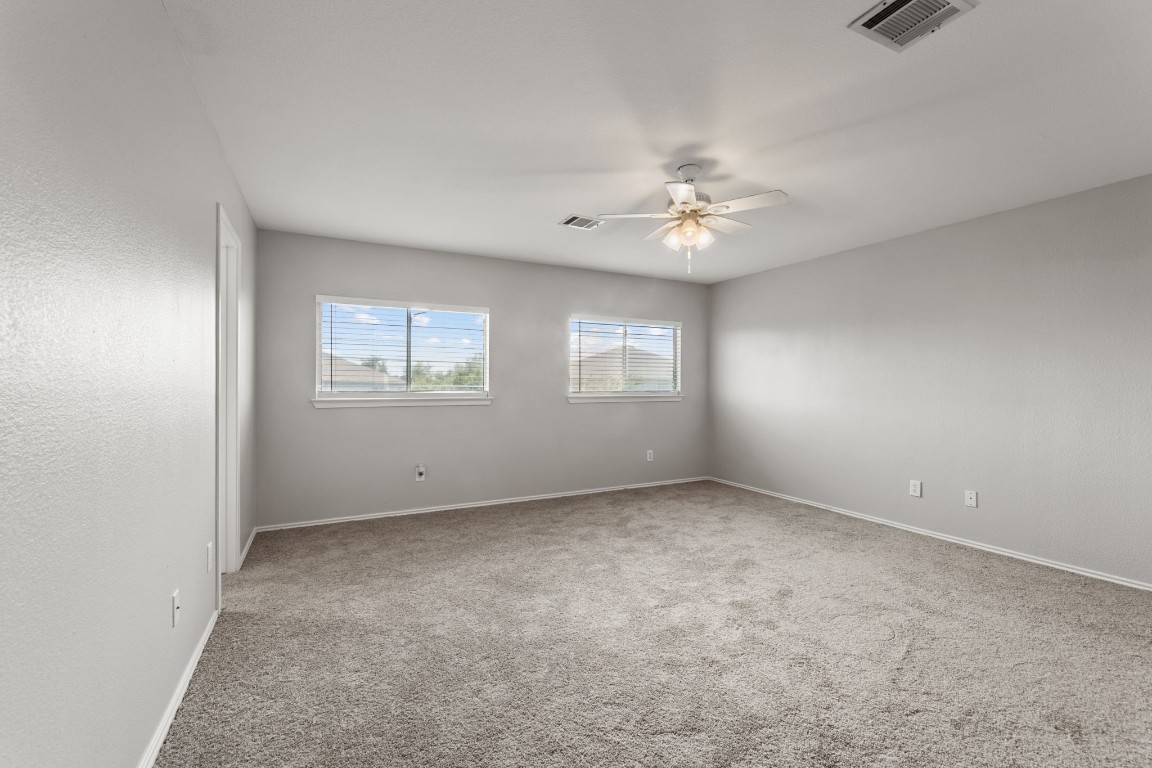 1308 Water Spaniel Way Round Rock, TX 78664 - Photo 13 of 25 an empty room with windows and ceiling fan