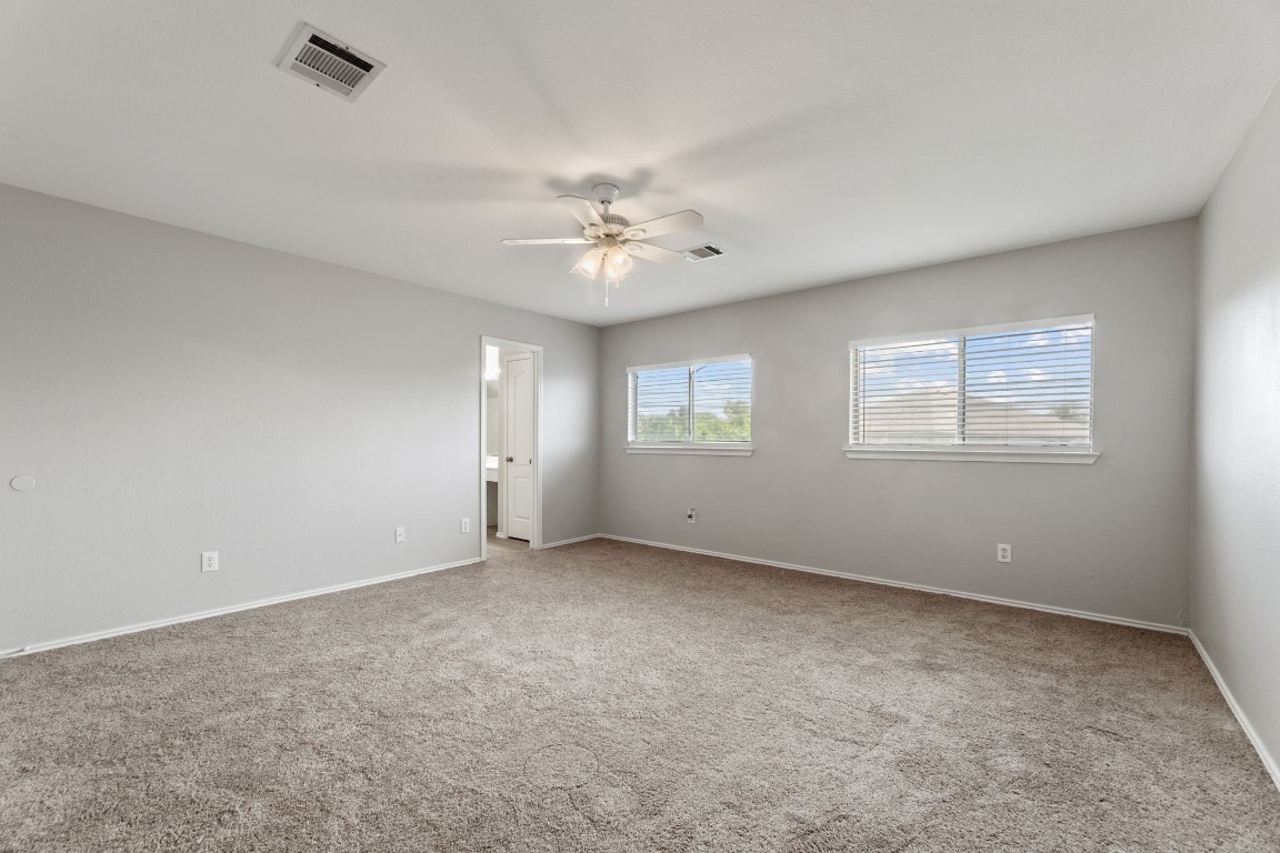 1308 Water Spaniel Way Round Rock, TX 78664 - Photo 15 of 25 an empty room with windows and ceiling fan