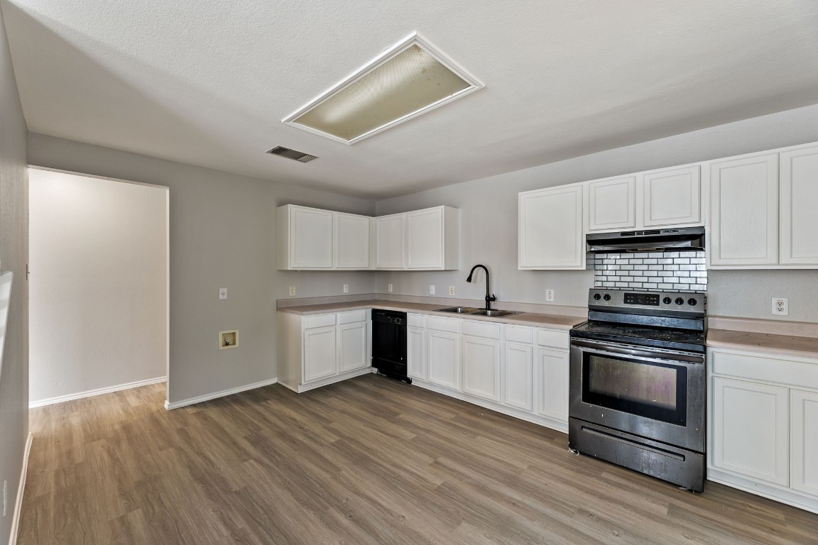 1308 Water Spaniel Way Round Rock, TX 78664 - Photo 8 of 25 a kitchen with a sink wooden floor and stainless steel appliances