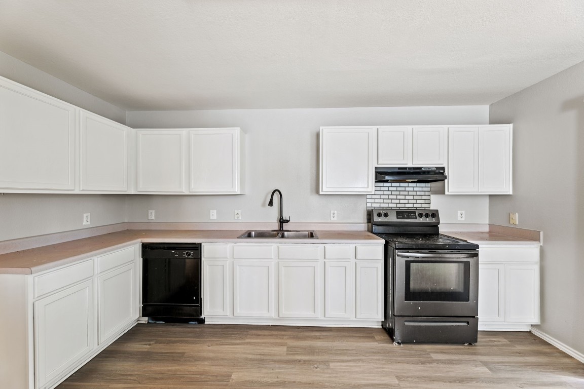 1308 Water Spaniel Way Round Rock, TX 78664 - Photo 9 of 25 a kitchen with stainless steel appliances a stove sink and cabinets