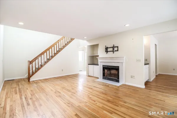 a view of a livingroom with wooden floor and a fireplace