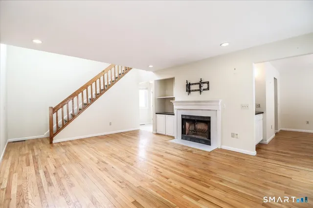 a view of a livingroom with wooden floor and a fireplace