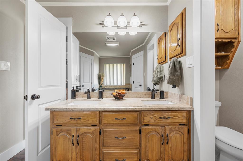 11541 Old Dallas Road West, TX 76691 - Photo 15 of 39 a bathroom with a granite countertop sink a mirror a vanity and a shower