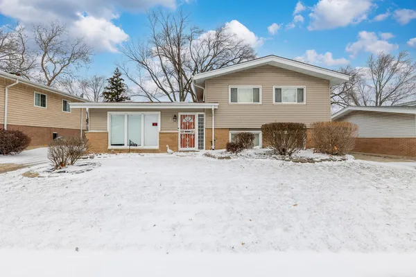 a view of a house with a yard covered in snow