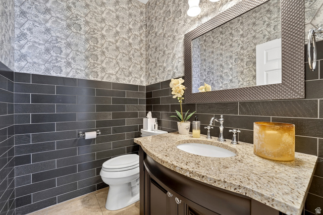714 Draper Heights Way Draper, UT 84020 - Photo 26 of 88 Bathroom with vanity, tile walls, light tile patterned flooring, and wallpapered walls
