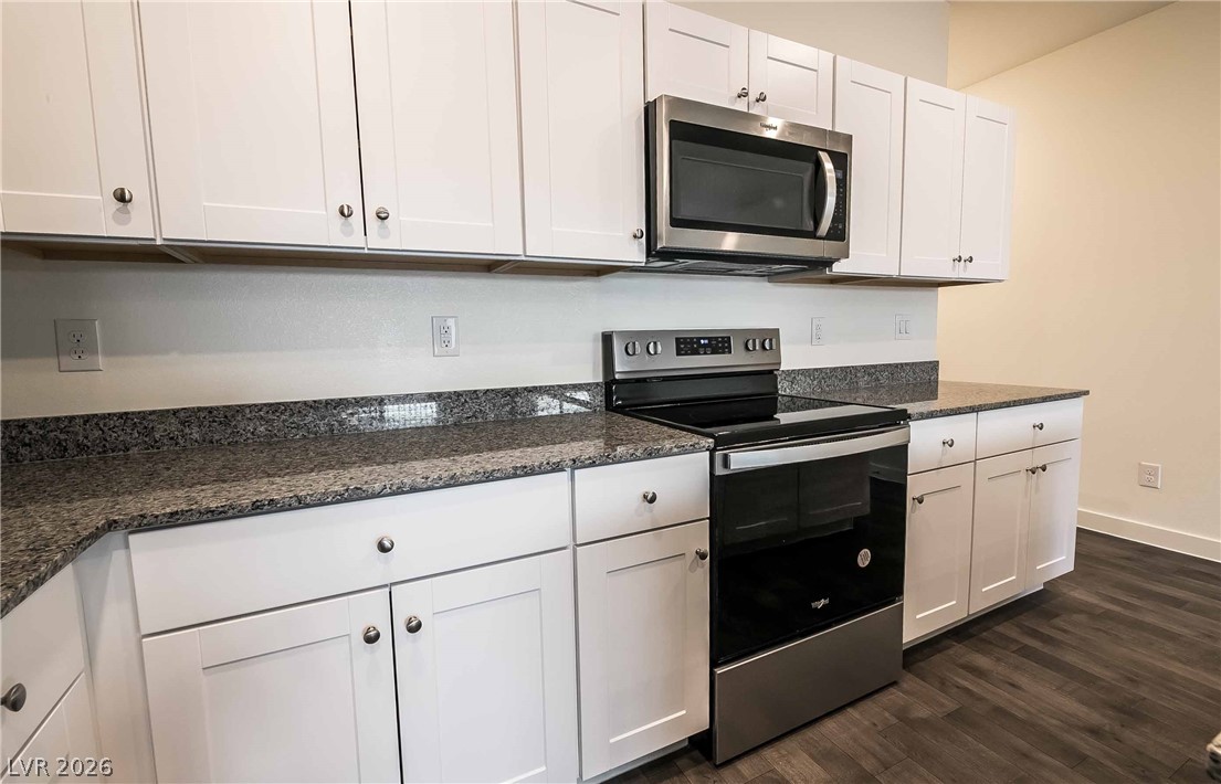 12749 Epperly Street Henderson, NV 89044 - Photo 7 of 22 A well-appointed kitchen features ample white cabinetry, sleek granite counters, and modern stainless steel appliances.