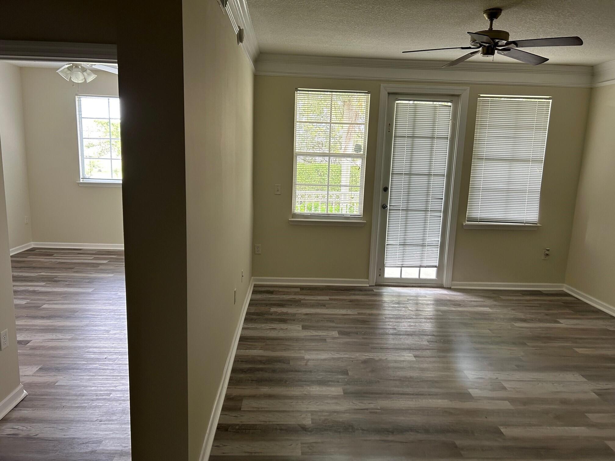 9825 Baywinds Boulevard, Unit 1206 Royal Palm Beach, FL 33411 - Photo 7 of 22 a view of an empty room with wooden floor and a window