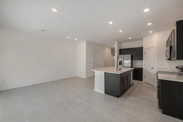 a large kitchen with a large counter top cabinets and stainless steel appliances